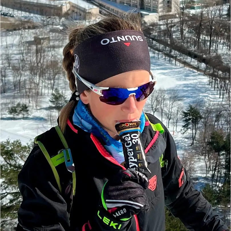 atleta en la nieve tomando un gel de corwn